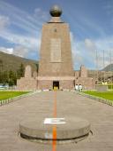 La Mitad del Mundo - fotografen har en fod på den nordlige halvkugle og en fod på den sydlige halvkugle